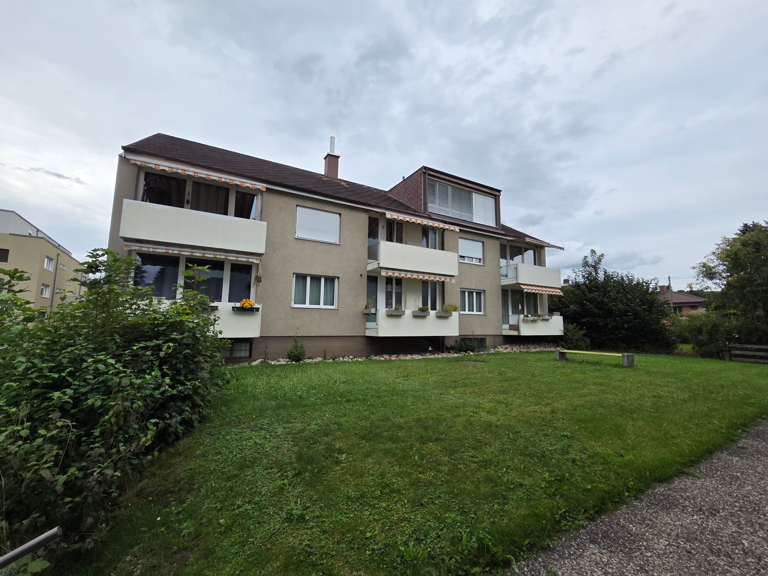 two story building, balcony on the first floor, green lawn in front