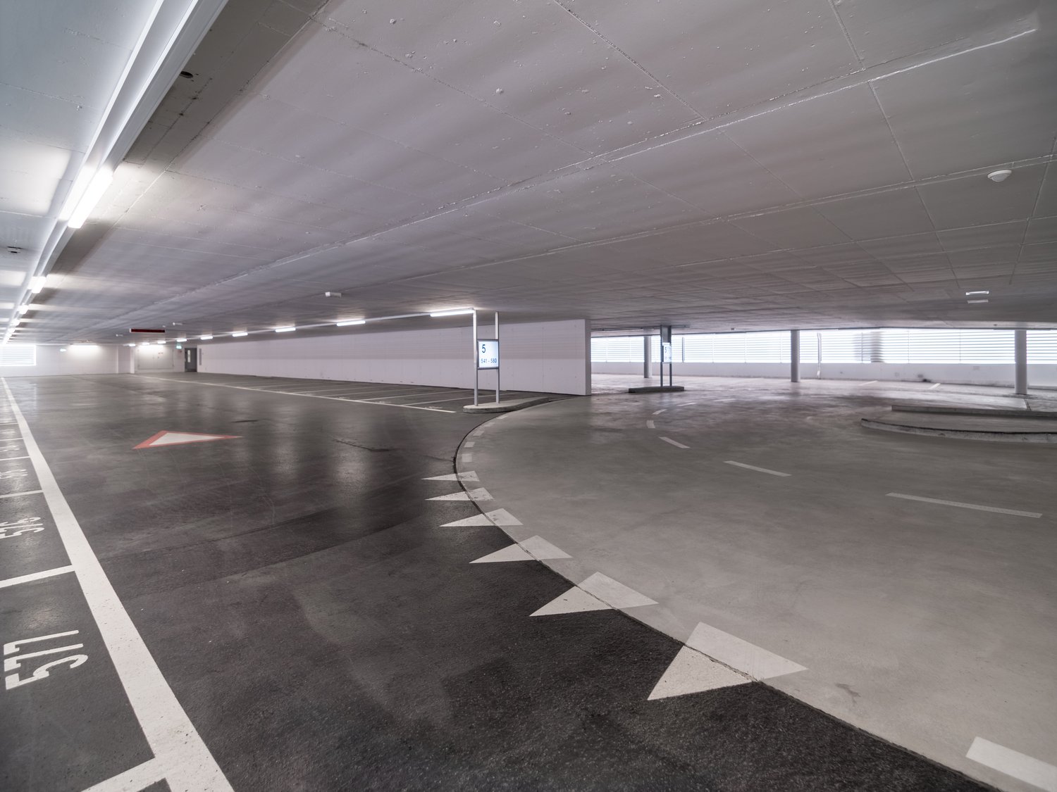 Underground parking lot with designated parking spaces and lane markings.