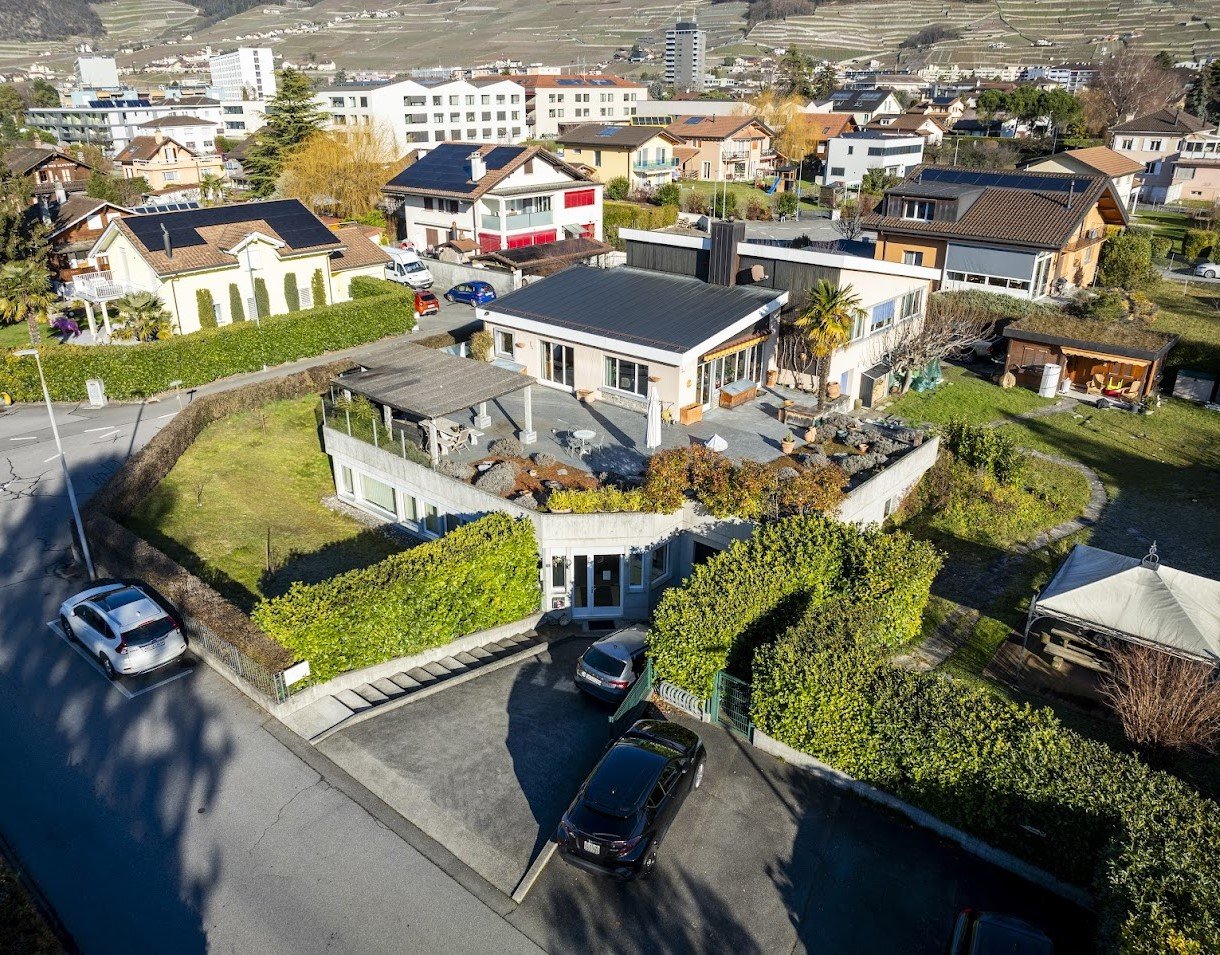 Modern architectural design, rooftop terrace, several parking spaces, green surroundings