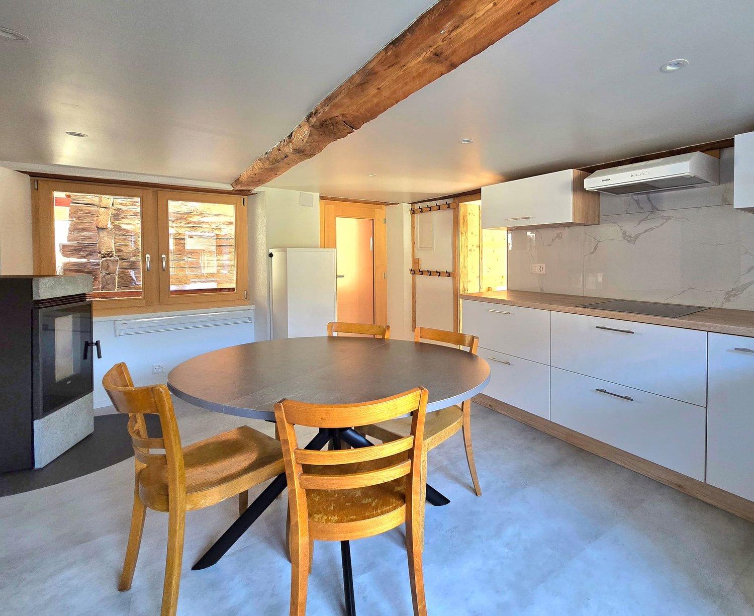 Dining table, wood chairs, white cupboards, granite countertop, gas stove, fireplace