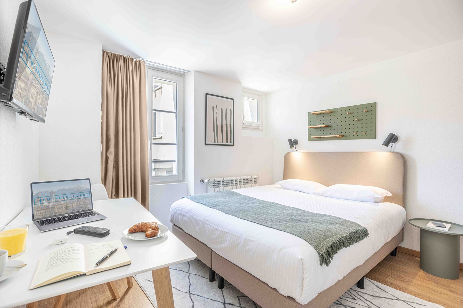 single bed, table, laptop, open book, mug, pen, croissant, lamp