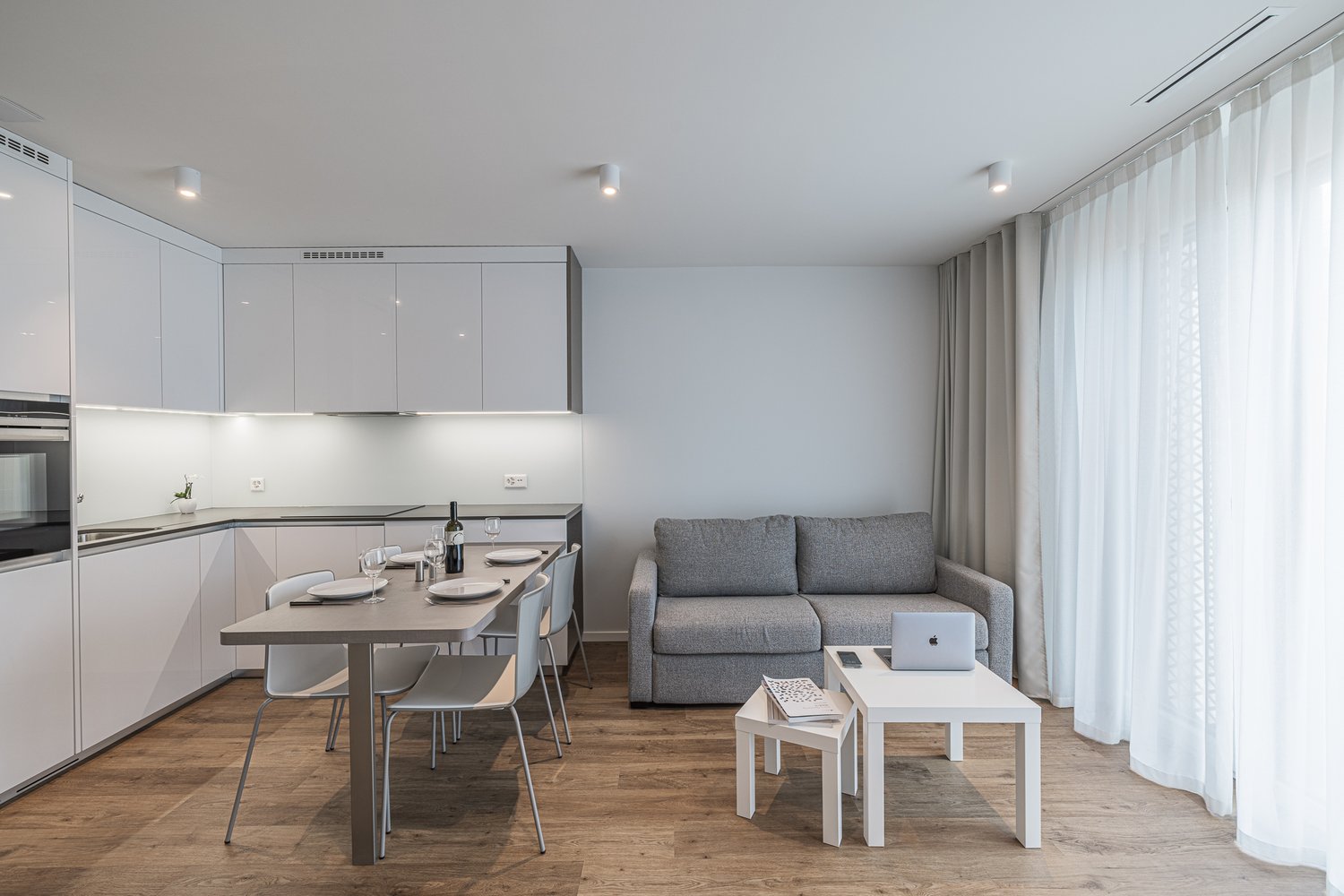 modern kitchen with dining area and living room with sofa and dining table