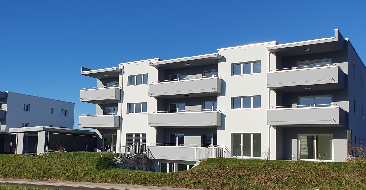 4 story building, white exterior, modern design, several balconies