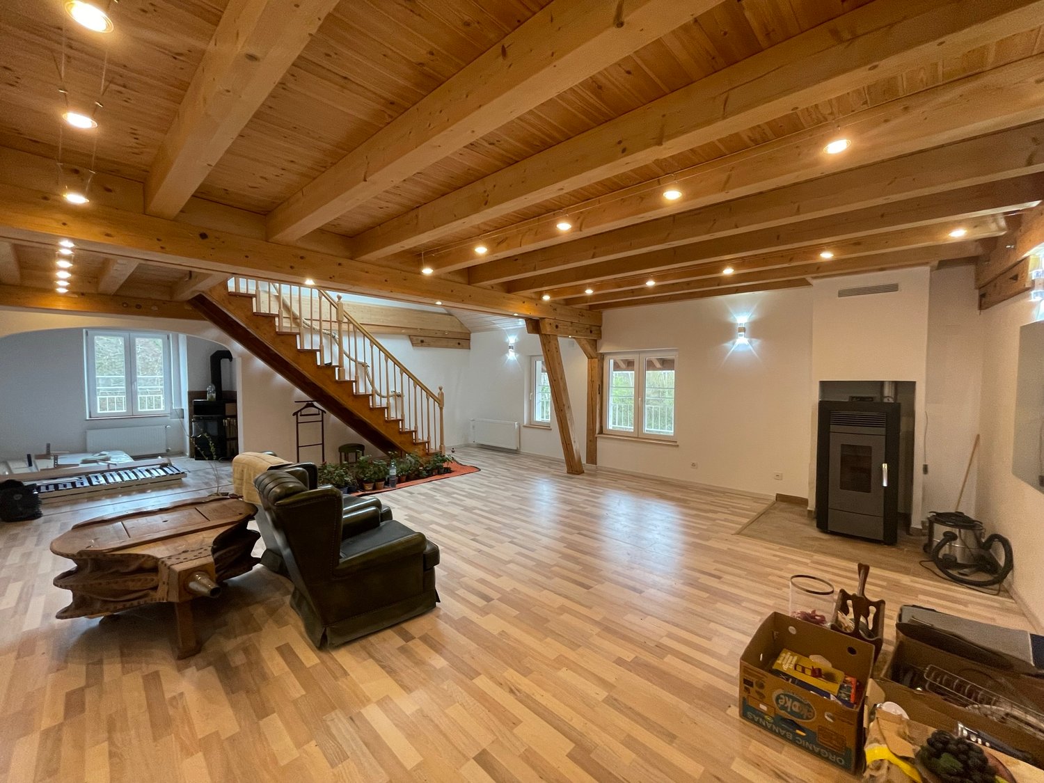 wooden floor, wooden beams, fireplace, wooden stairs, armchairs, wooden table, staircase