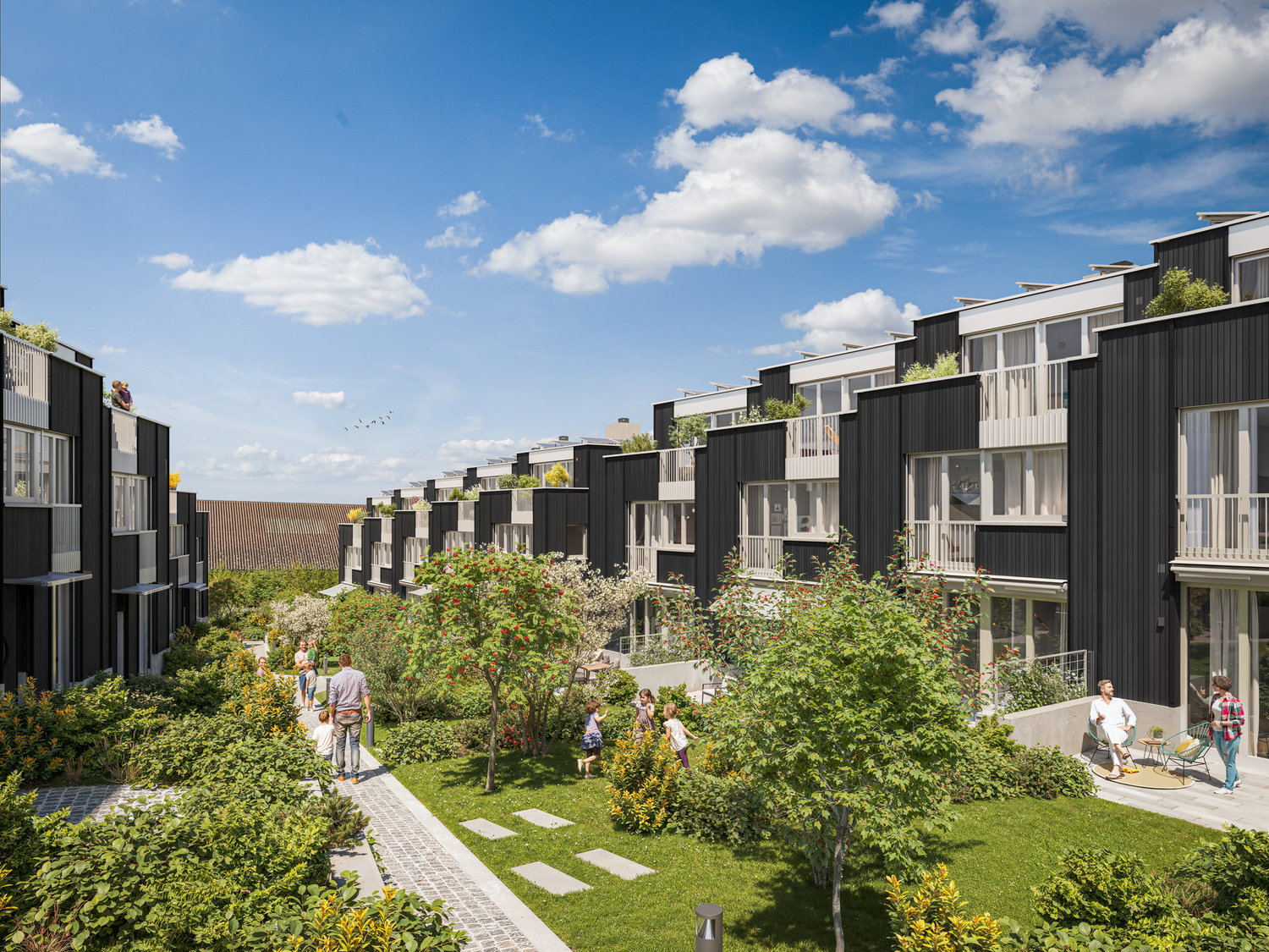 Multistory residential buildings with black and white facades, surrounded by lush greenery and landscaped gardens. People walking through the well-maintained outdoor areas.