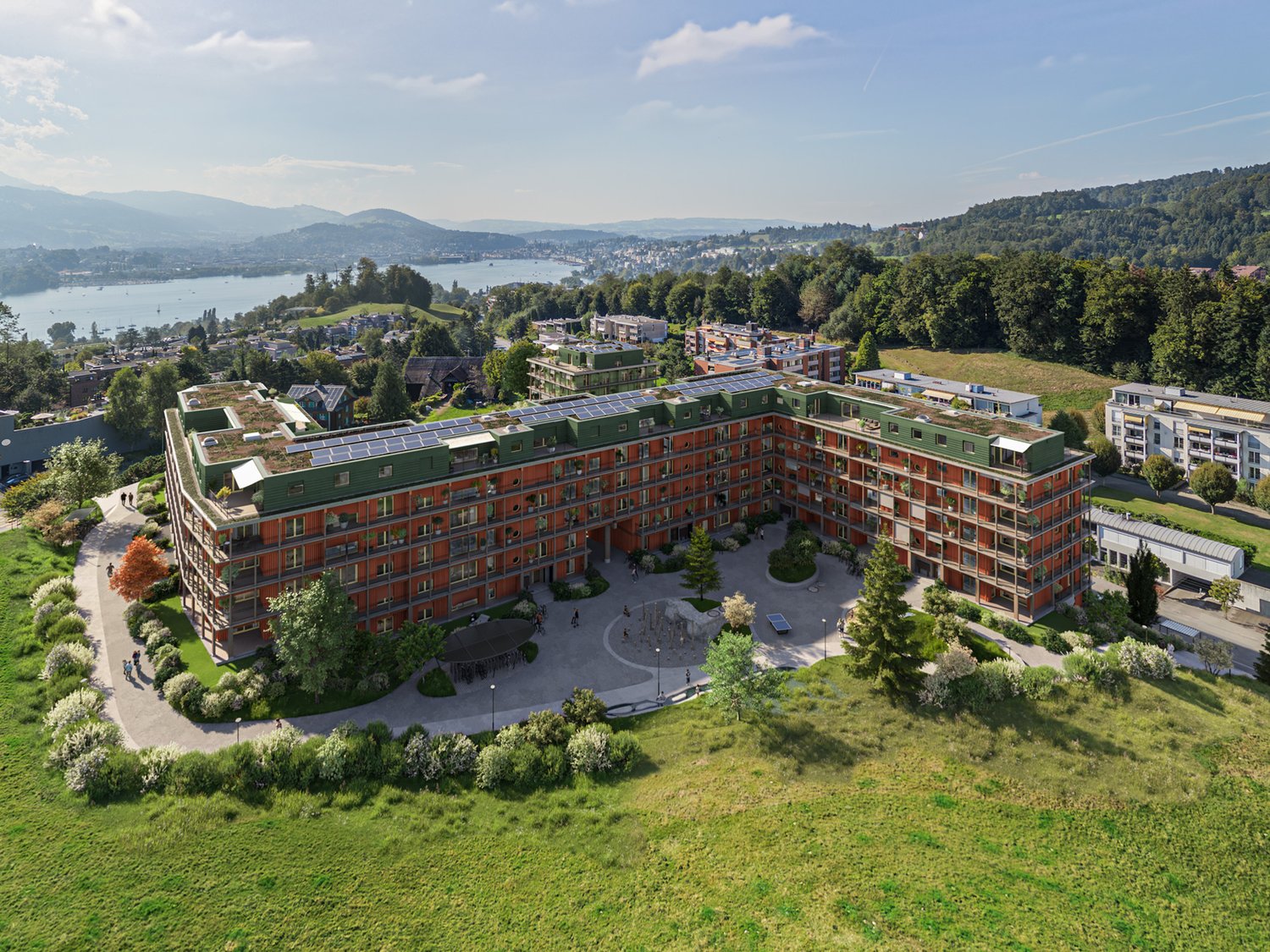 Red brick building, green roof, solar panels, multiple floors, courtyard, lake view, multiple buildings in the background