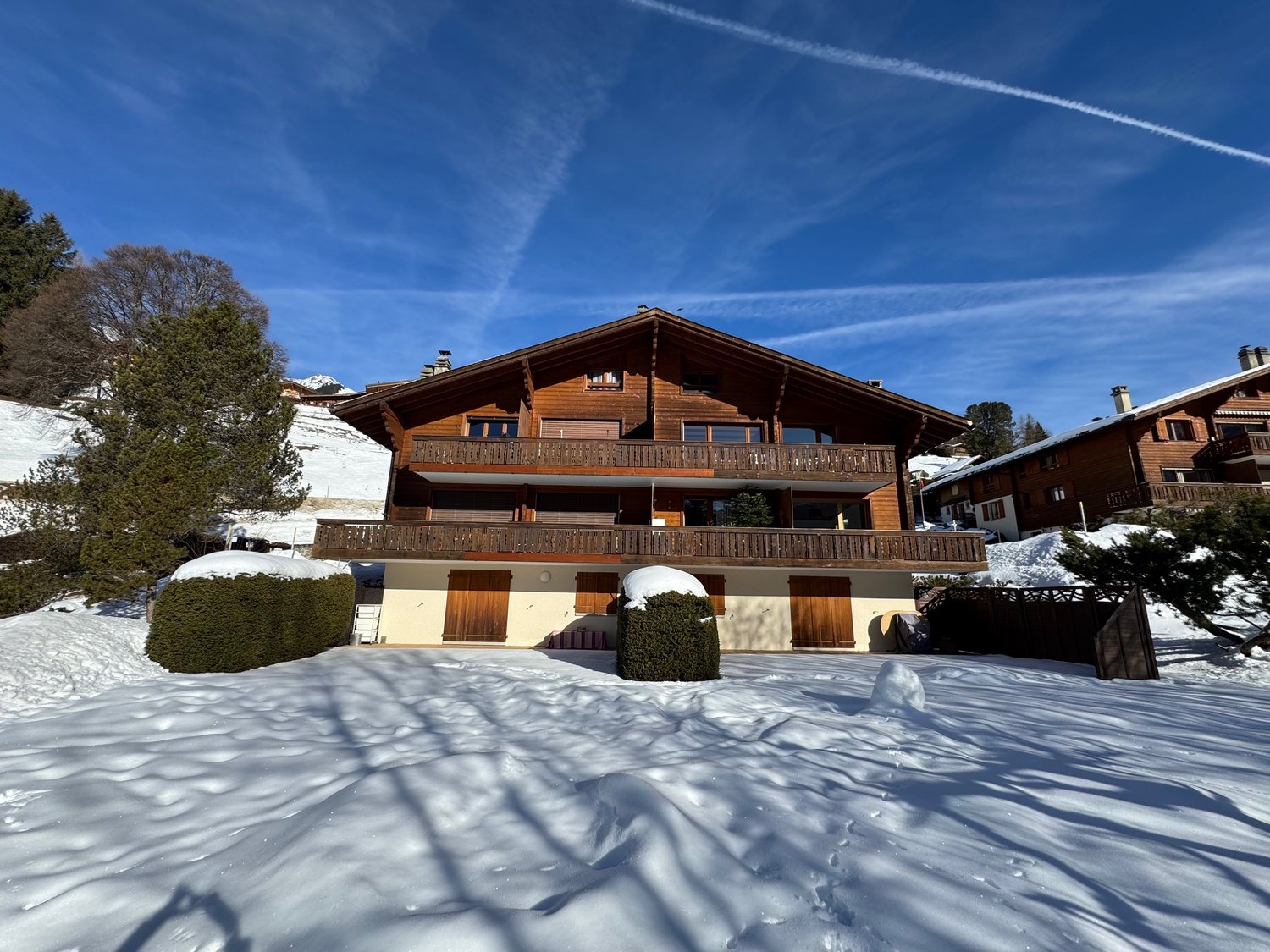 wooden chalet, large balcony, multiple levels, snow covered ground