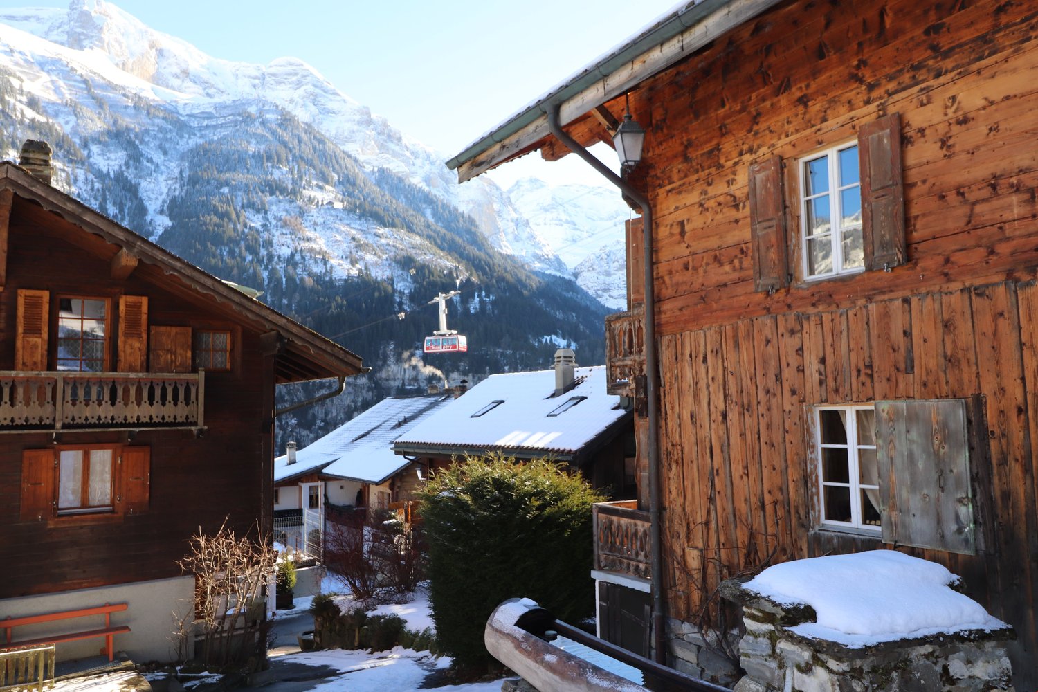 A wooden building with a wooden facade and balcony in a snowy mountainous region