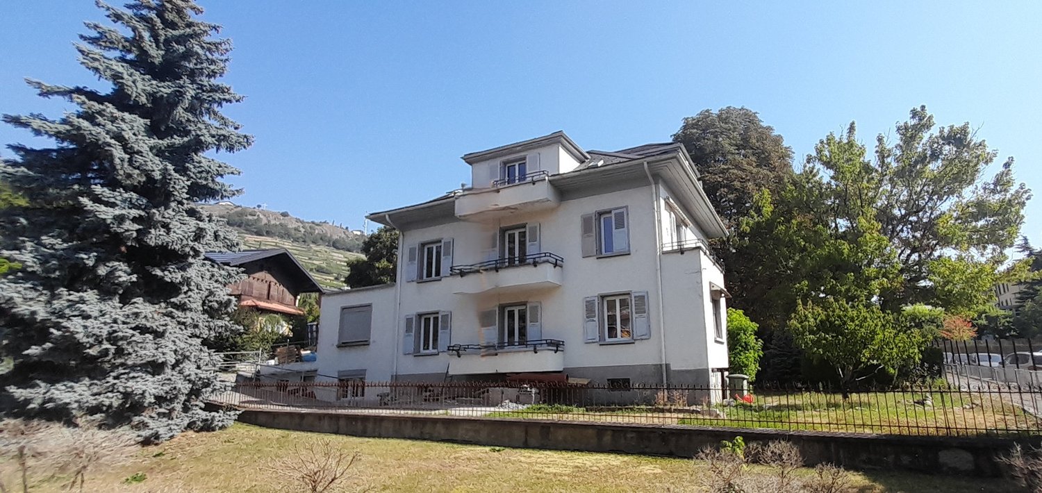 3 story house, white exterior, several balconies
