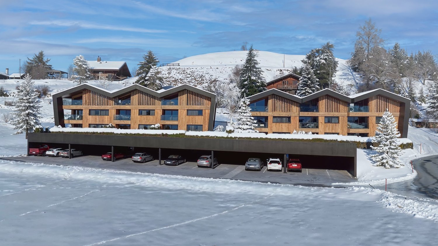 4 story wood structure, covered parking, winter environment, multiple windows, sloping roof