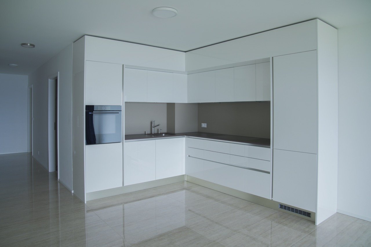 modern kitchen with white cabinets, stainless steel appliances, tiled floor, and a sink with a faucet