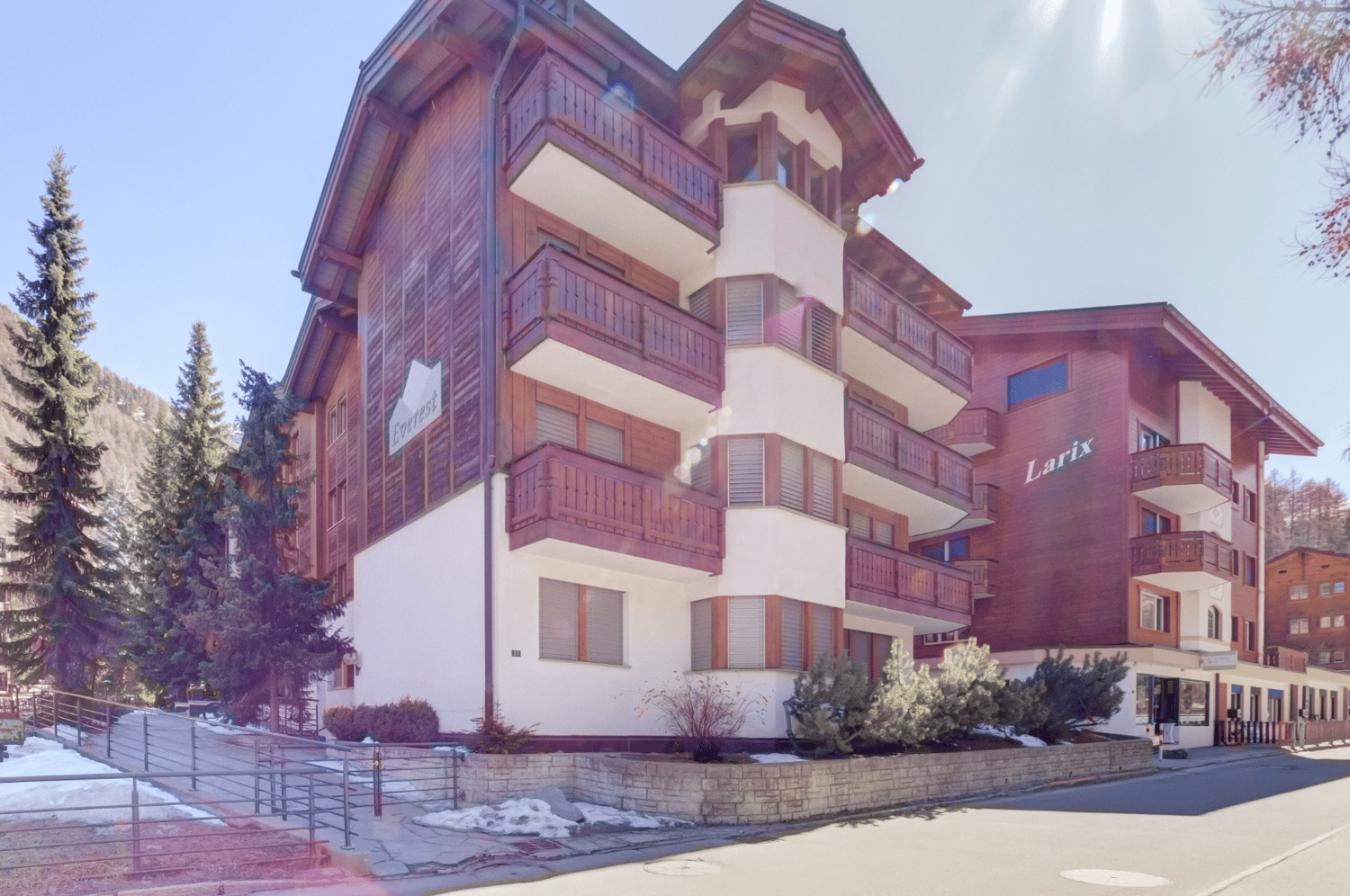 3 story building, wooden exterior, balconies, snow on the ground
