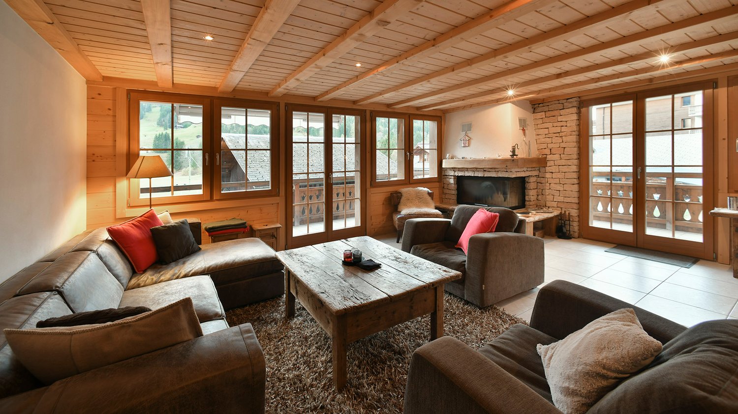 fireplace, wooden ceiling, couches, coffee table, lamps