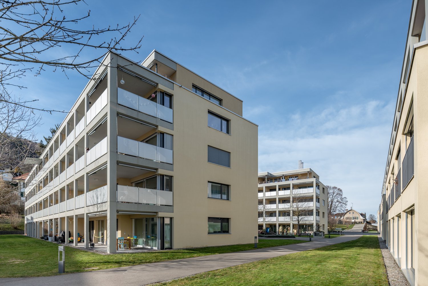 Modern, multi-story apartment building with multiple balconies and glass windows.