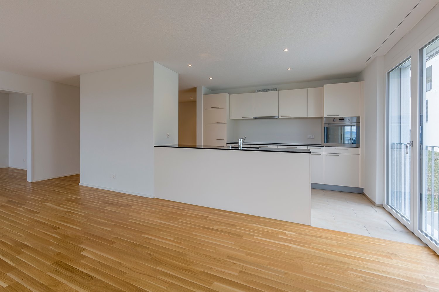 modern kitchen, white cabinets, wooden floor, large windows, balcony