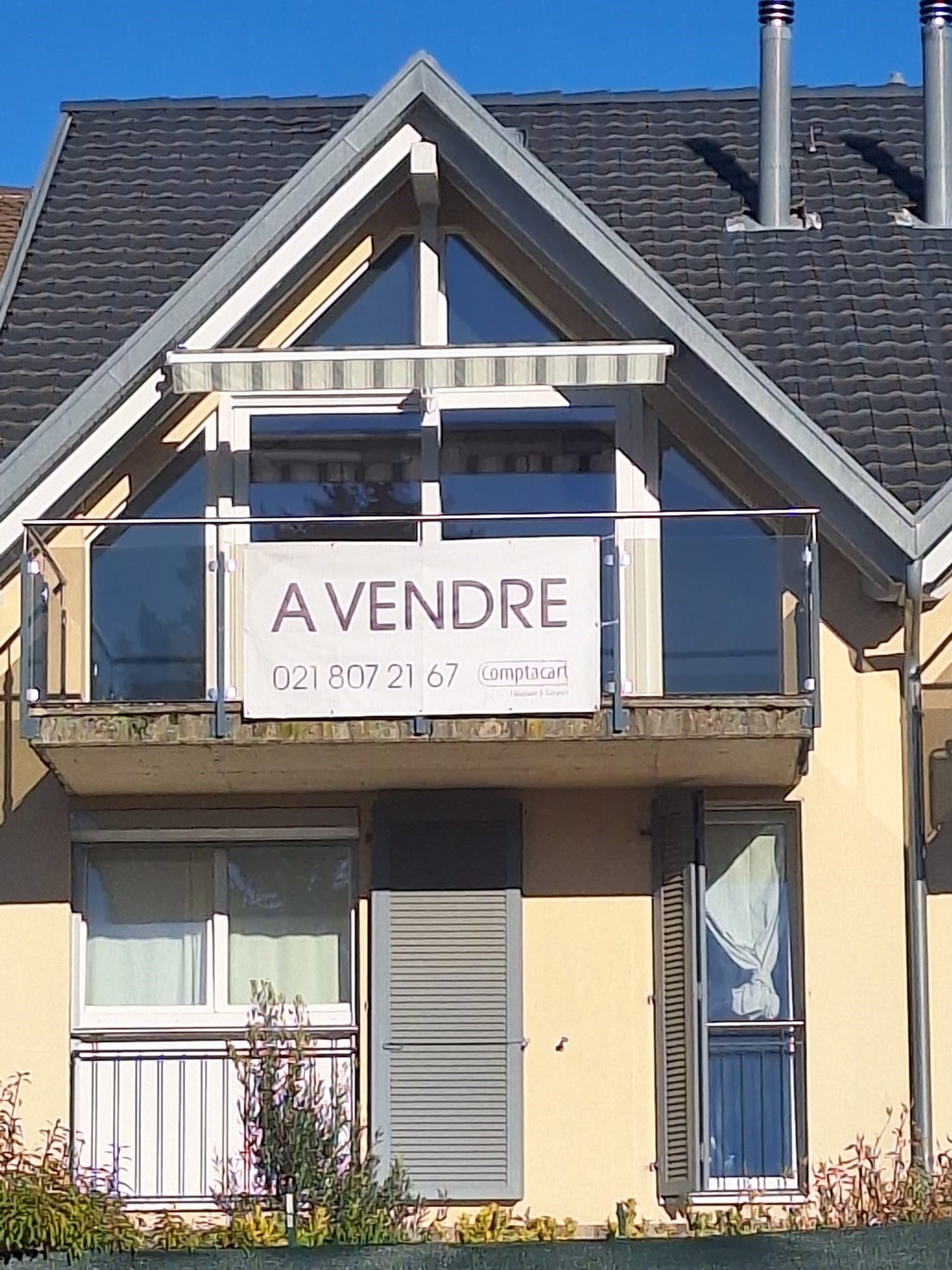Terraced house, two story, balcony on first floor, yellow exterior, double chimneys