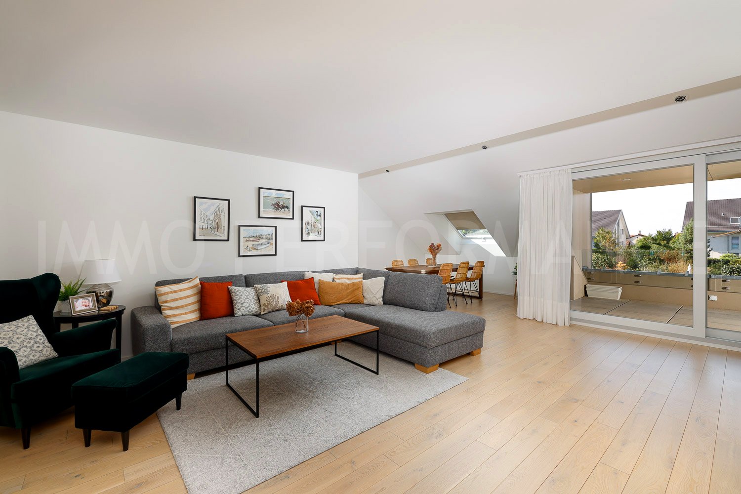 Balcony, wooden floor, large couch, wooden table, glass sliding door, lamps, paintings, wooden chair