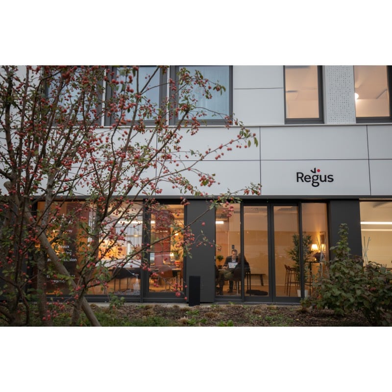 modern building, glass walls, entrance area, Regus sign, greenery, seating area
