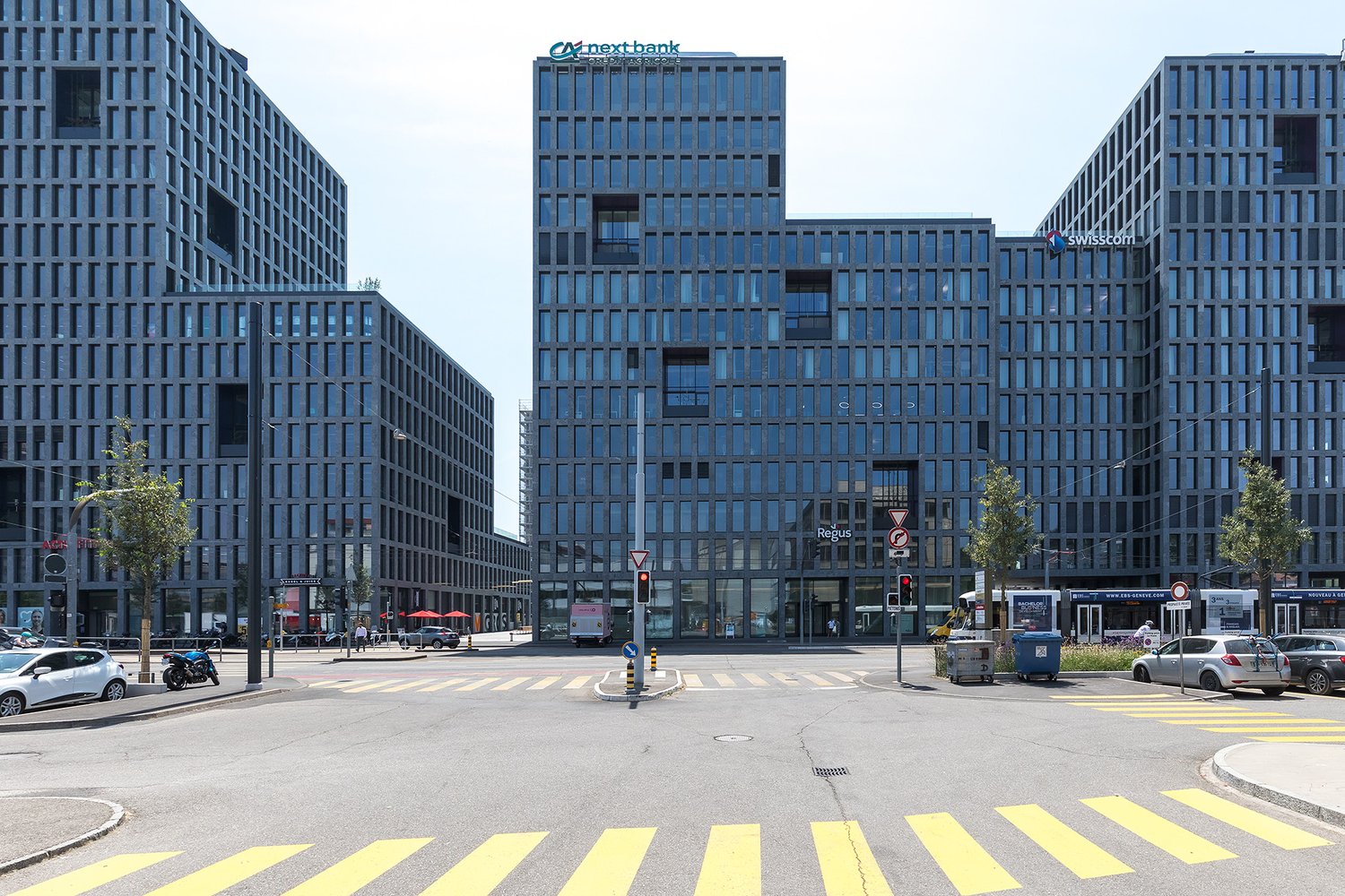 modern office building, grey facade, many windows, located at a busy intersection