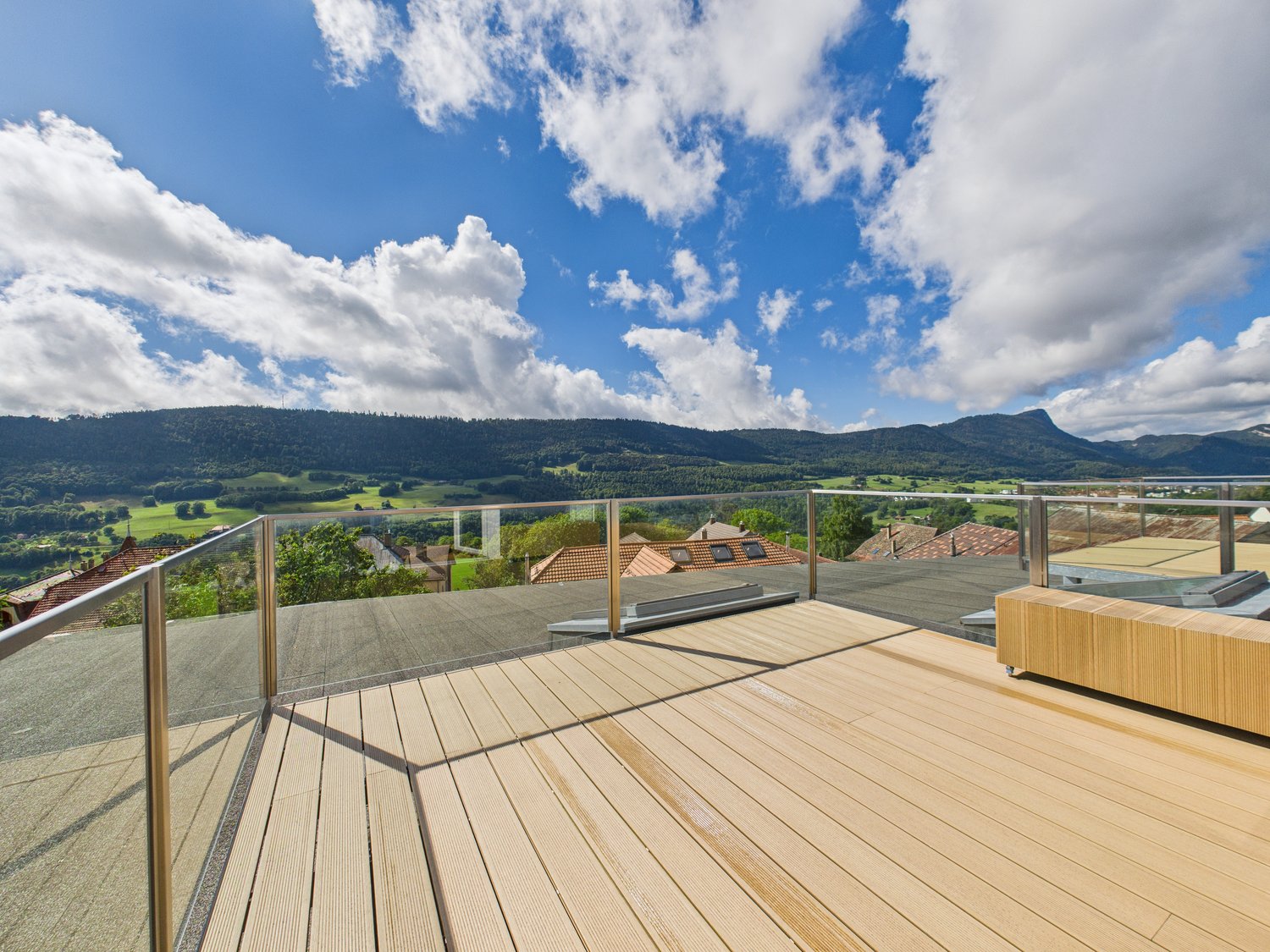 Wooden floor, glass railings, view of mountains