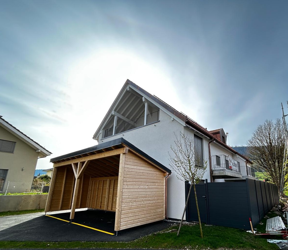 2 story house, white exterior, wooden garage, black roof, balcony, fence