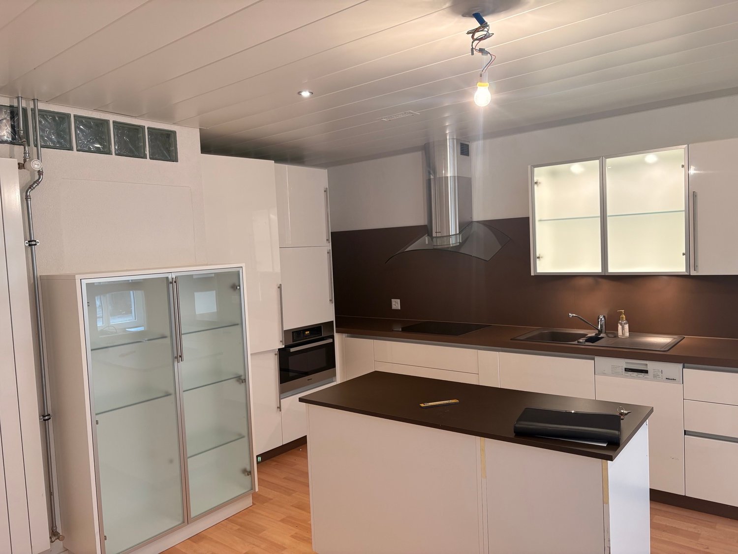modern kitchen, granite countertops, under-counter microwave, built-in oven, large sink, dishwasher, wooden floor, appliances in good condition