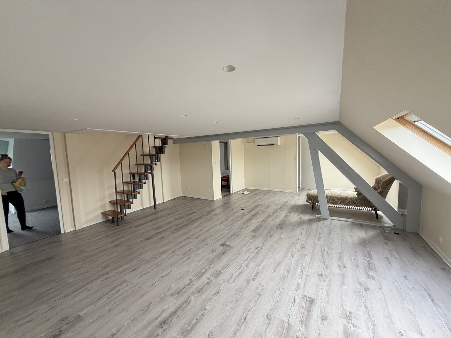 Empty room, staircase leading to upper floor, AC mounted on wall, window in room