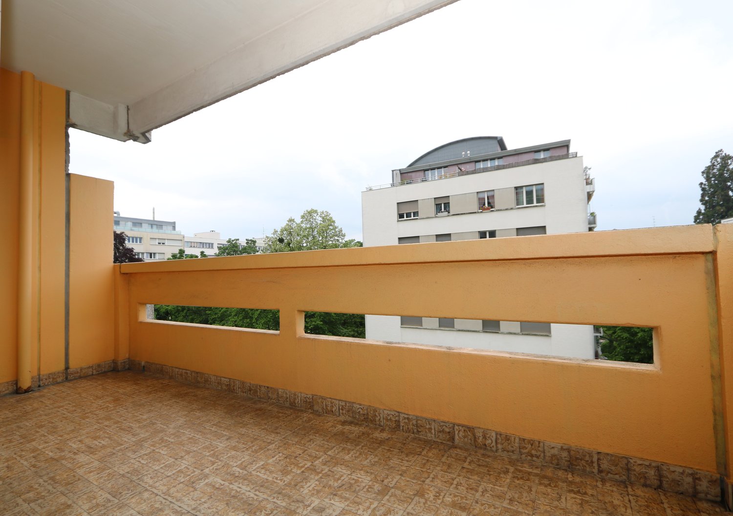 balcony with tiled floor, yellow balustrade, view of cityscape