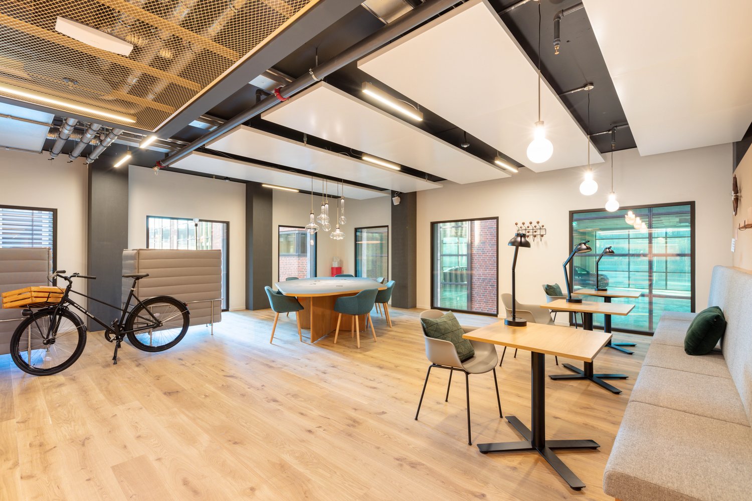 Open meeting space with round table, chairs, couches, and a bicycle