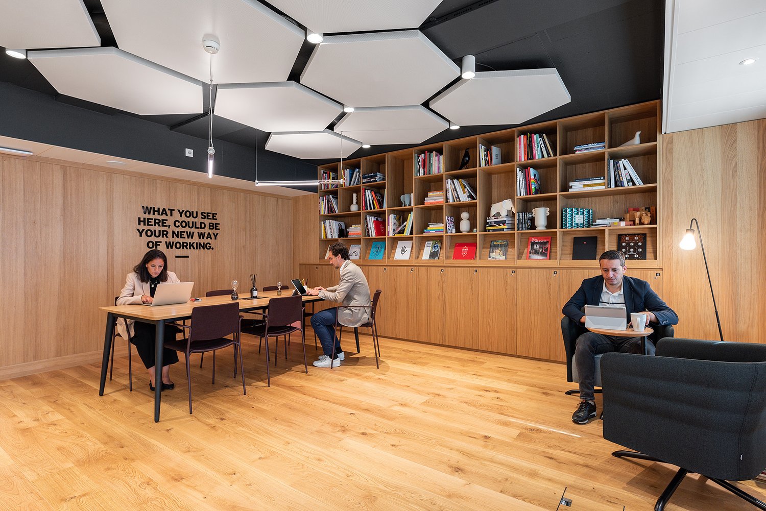 Office: wood flooring, wooden shelves, round tables, swivel chairs, desk lamps