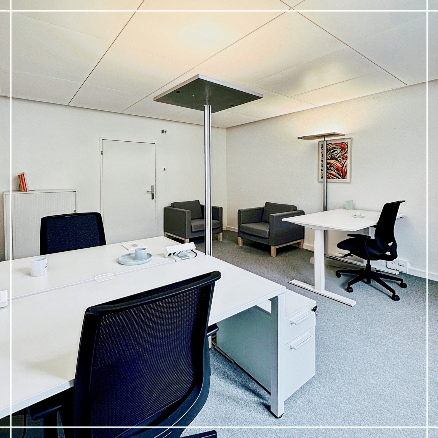 modern office room with desks, two chairs, adjustable height desks, standing lamps, radiator