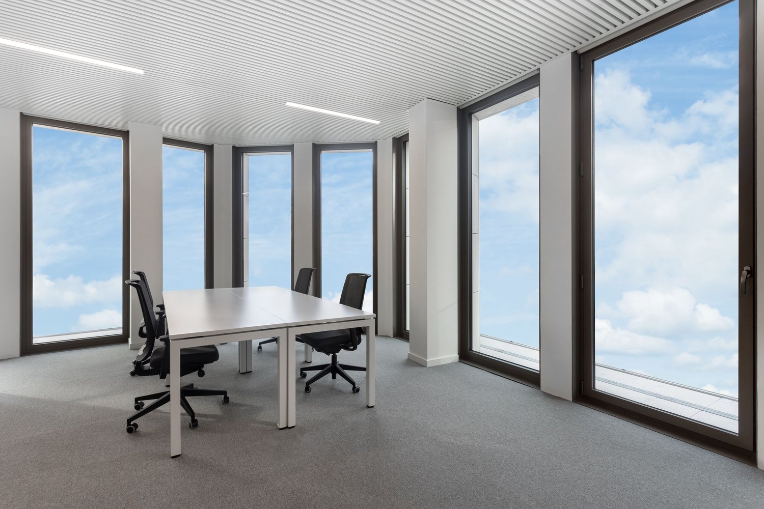 modern office room, white table, black chairs, large windows, carpeted floor