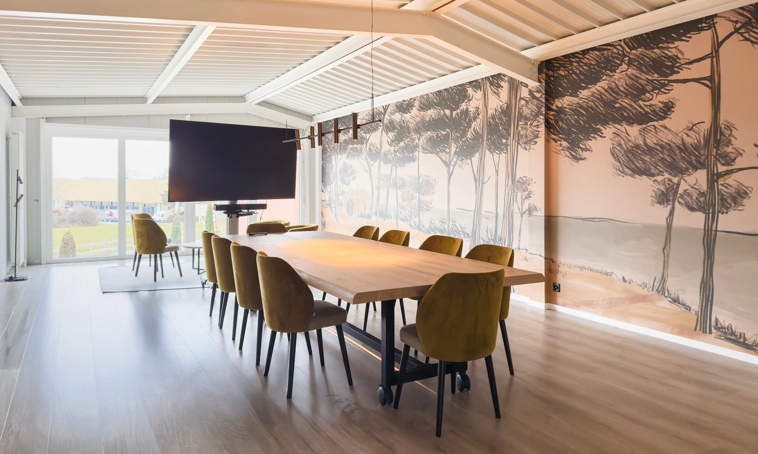 long dining table, 12 chairs, large screen on wall, wooden floor, large windows