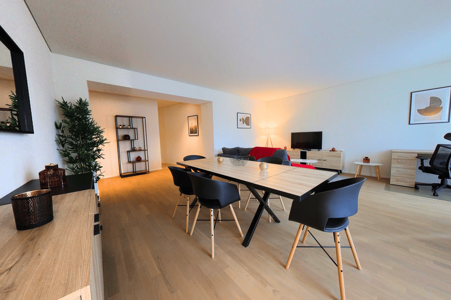 dining area with table and chairs, plant, mirror, TV, couch, shelves, office chair