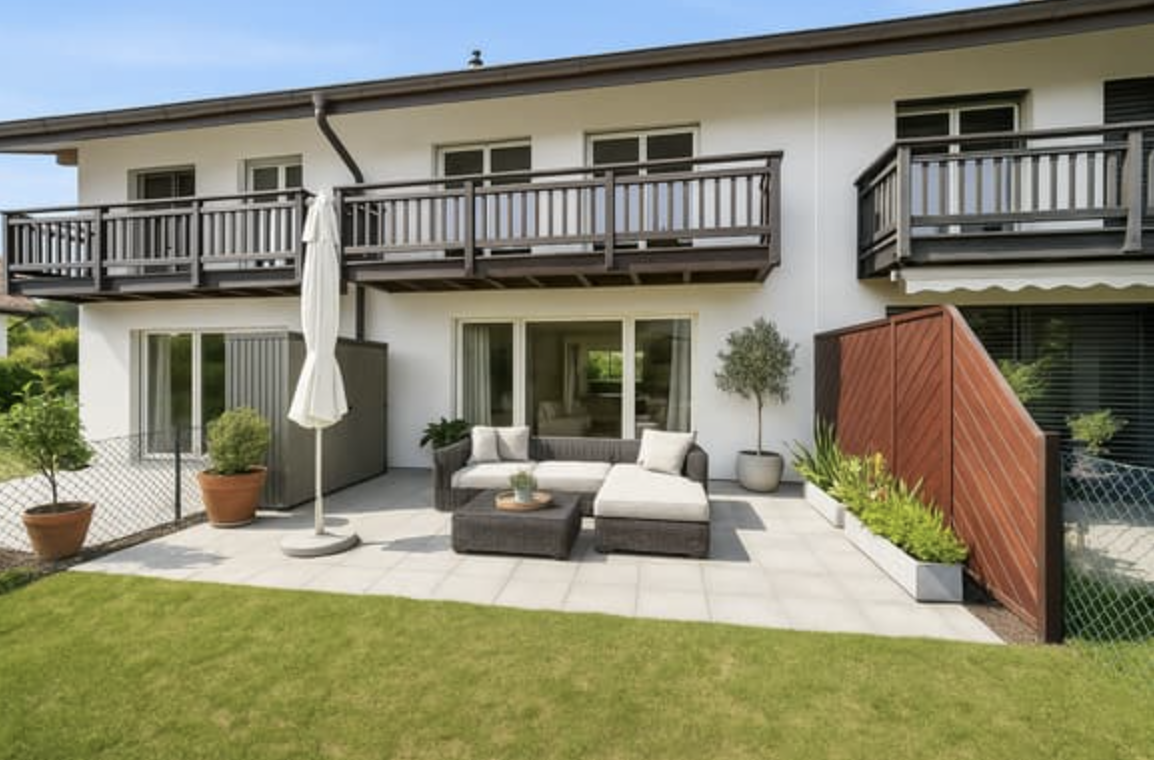 white two story house with balcony, outdoor sofa and coffee table, patio, fence