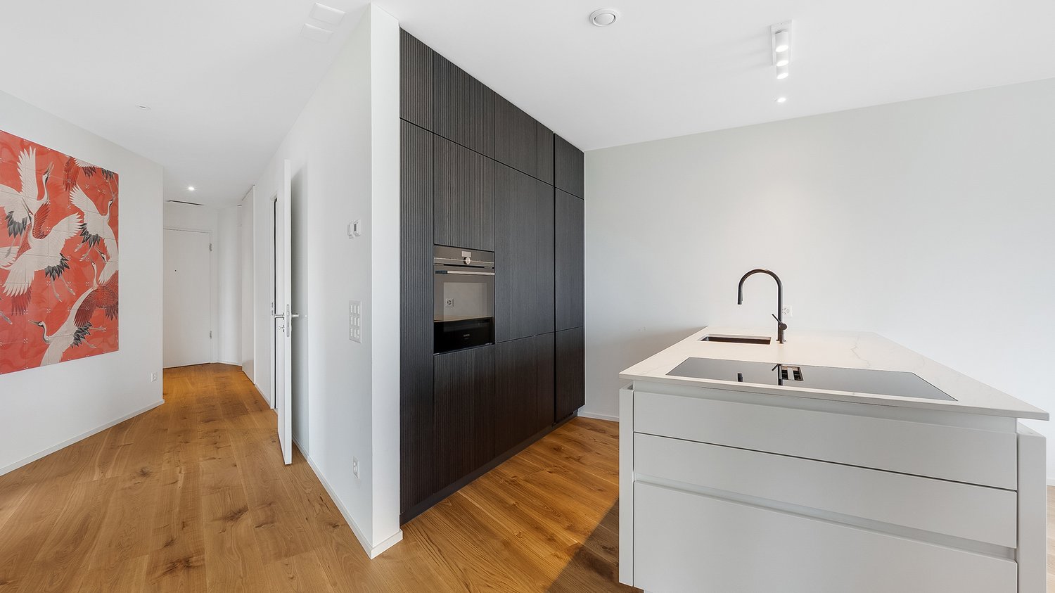 Modern kitchen, wooden floor, wall painting, white countertop, modern cabinets, integrated appliances