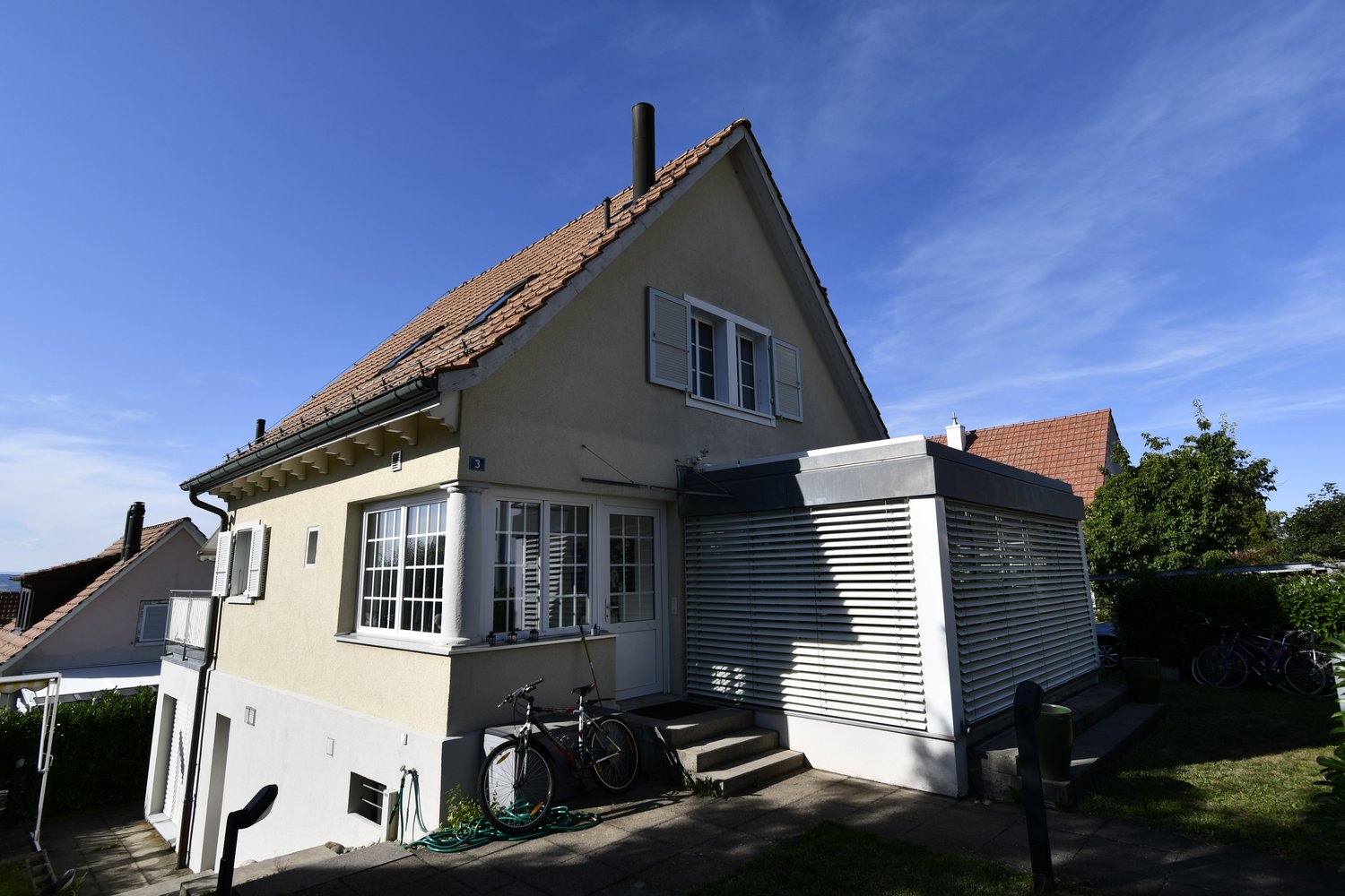 detached house, brown roof, beige facade, large window, garage