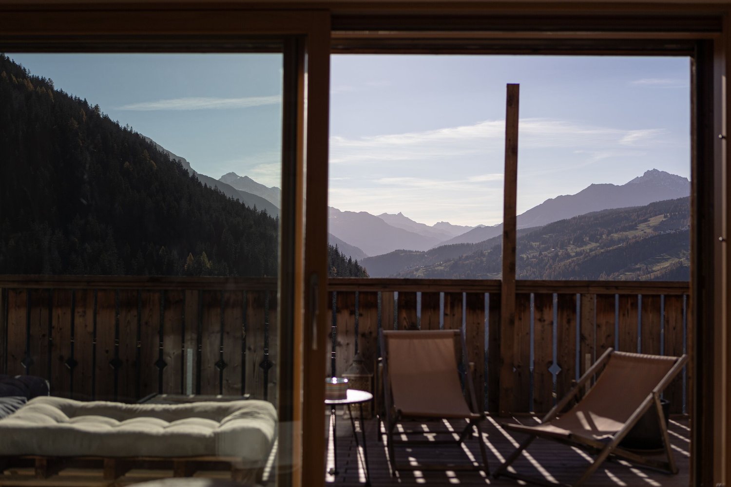 Wooden railing, outdoor furniture, open to terrace with view of mountains