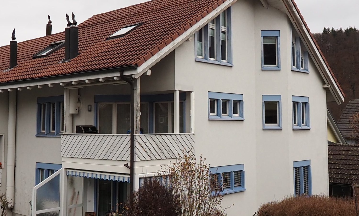 2-story house with a balcony, red tile roof, white exterior walls, and large windows.