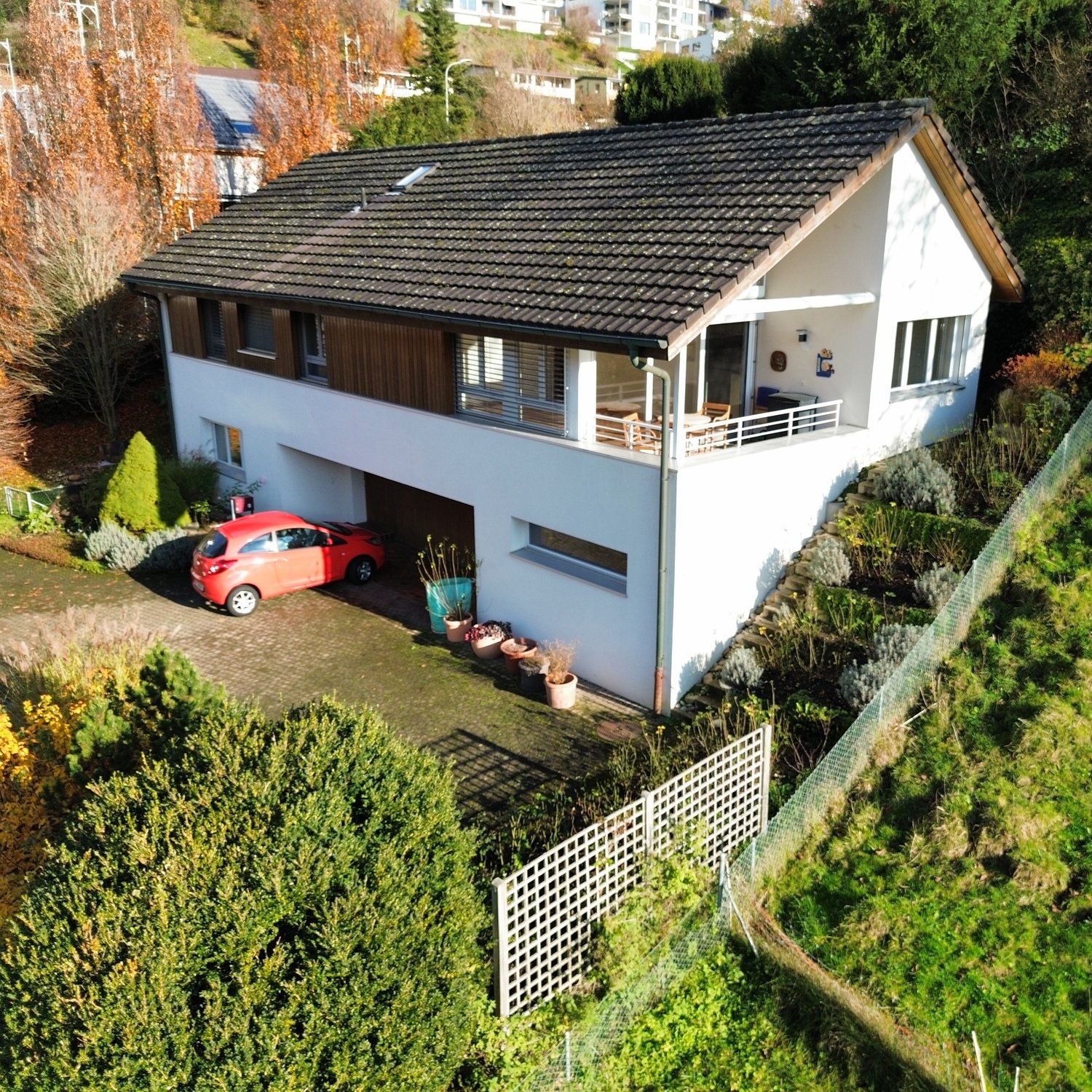 two-story house, brown roof, glass windows, garage, car parked, outdoor terrace, garden