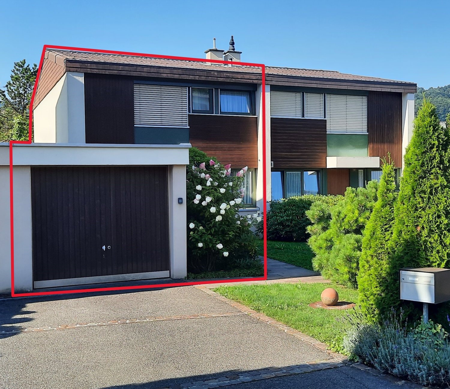 2 story house, brown walls, window shutters, garage, mailbox, green grass, flower plant