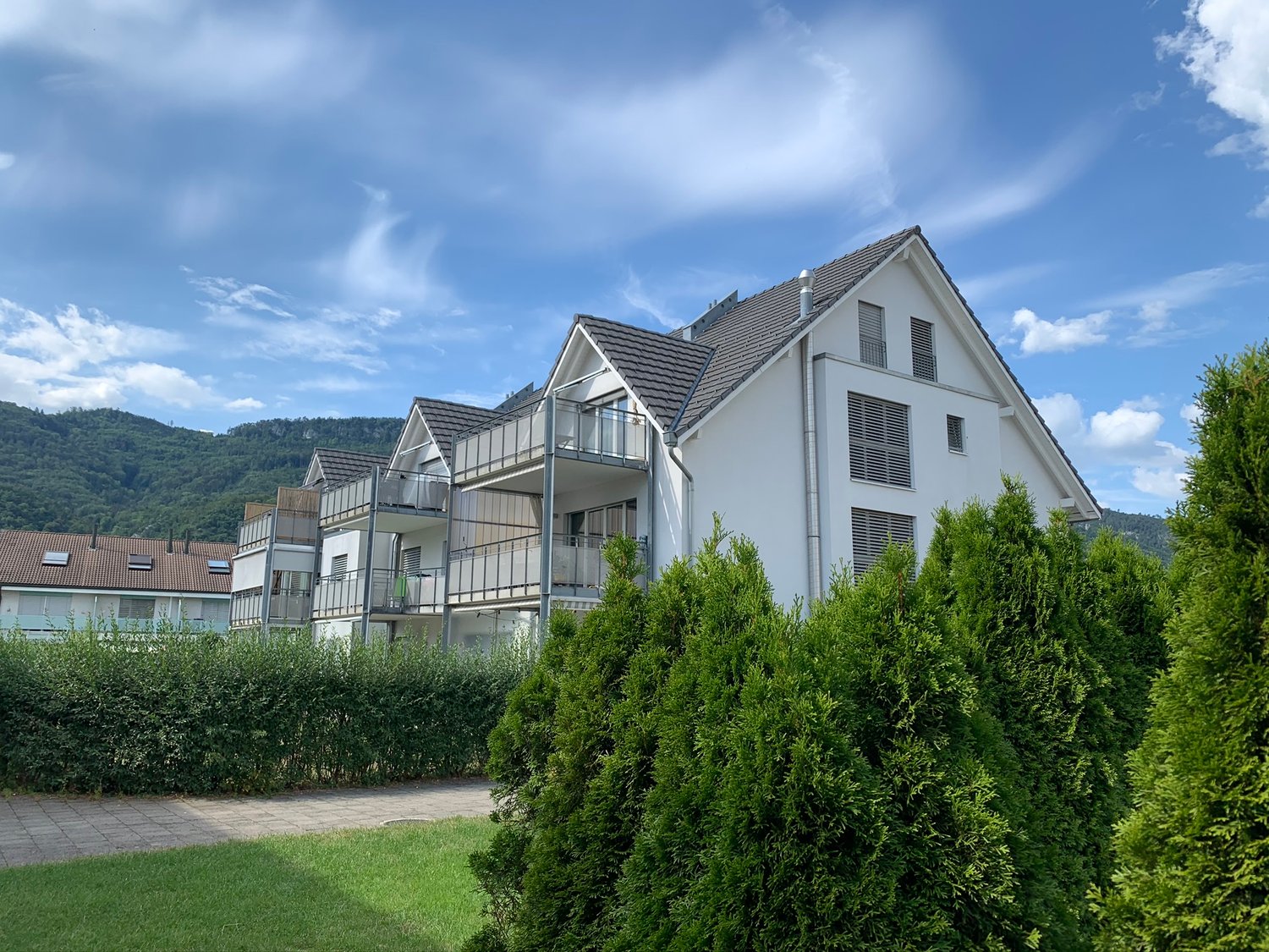 modern white house, 2 balconies on upper floor, brown roof