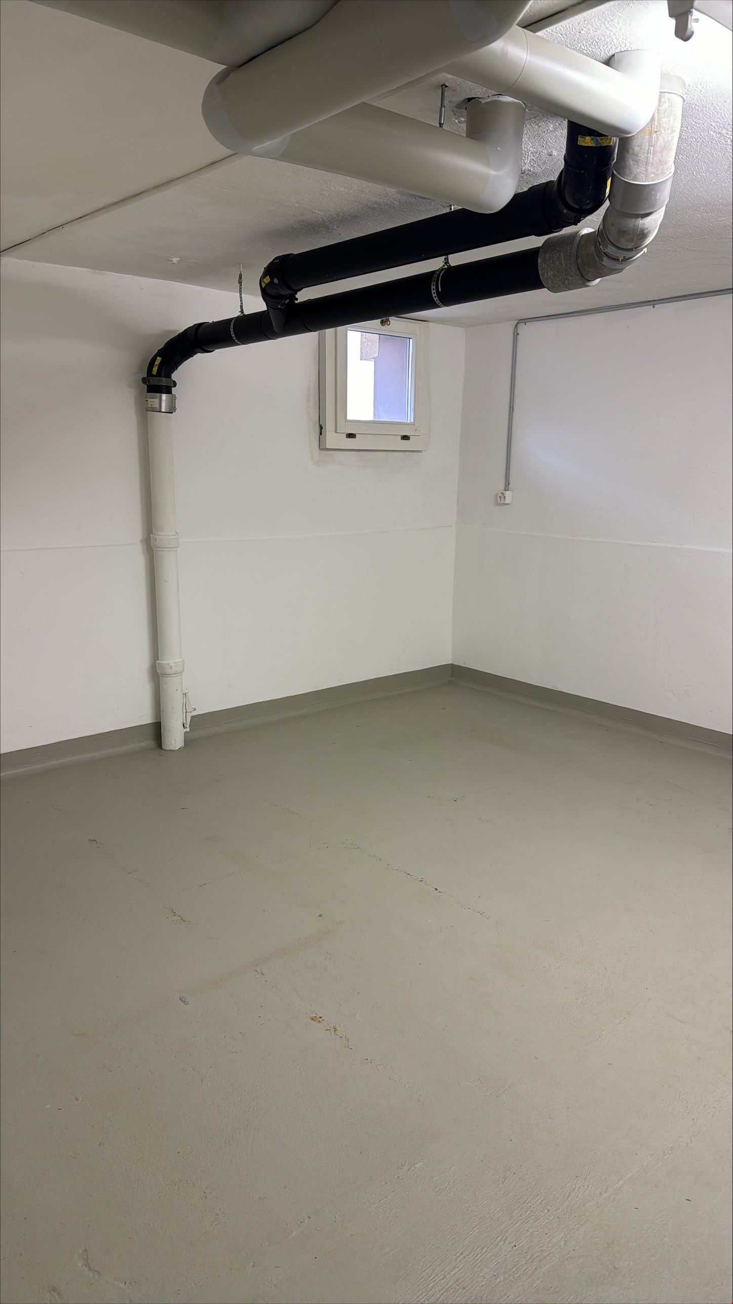 empty room, white walls, pipes, small window