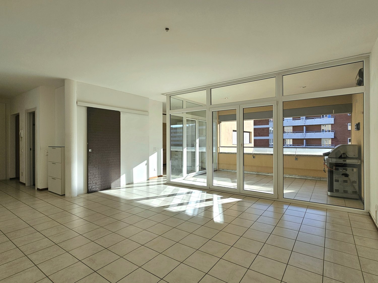 tiled floor, sliding glass doors to balcony, white walls, no furniture