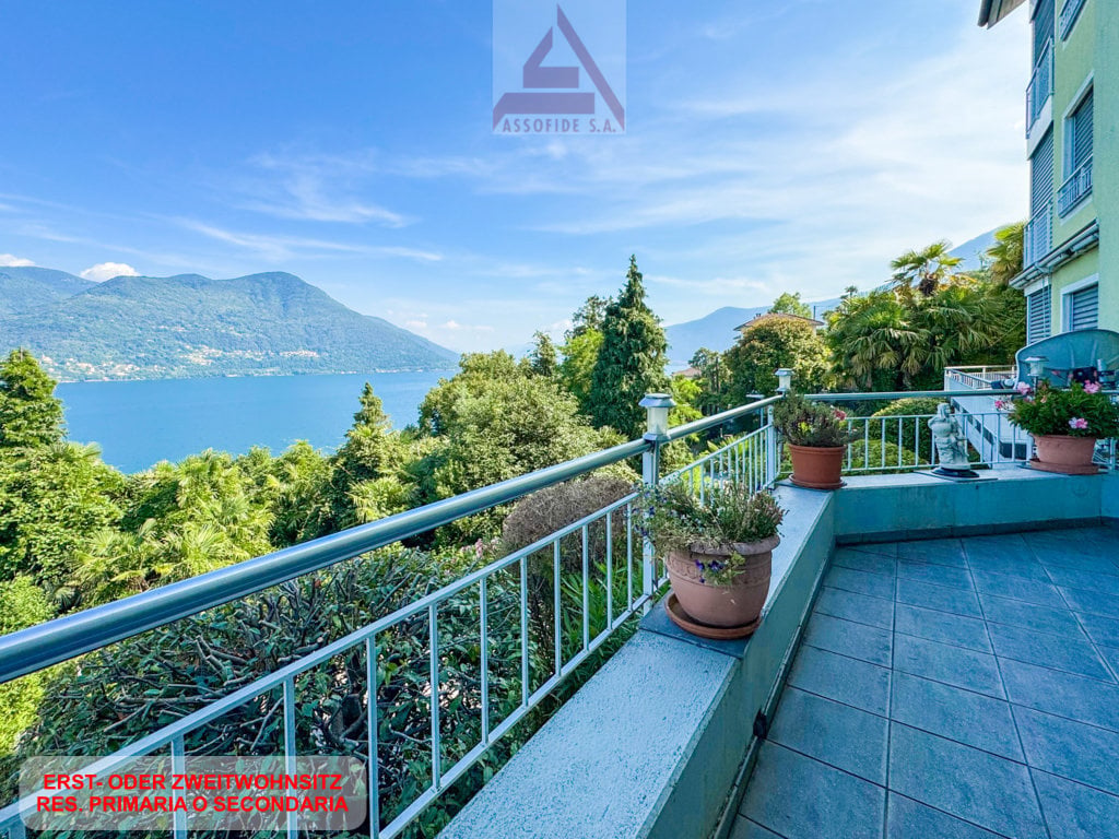Balcony with a view of the lake and mountains, potted plants, tiled floor, railing