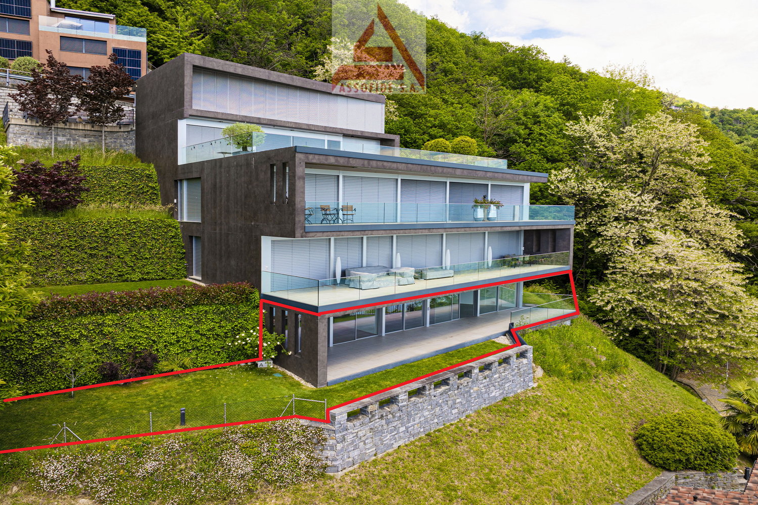 Modern house with terrace and glass windows, built on a sloped area