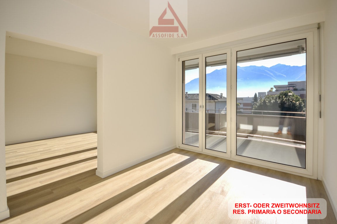 Empty room with sliding doors to a balcony and a view of mountains