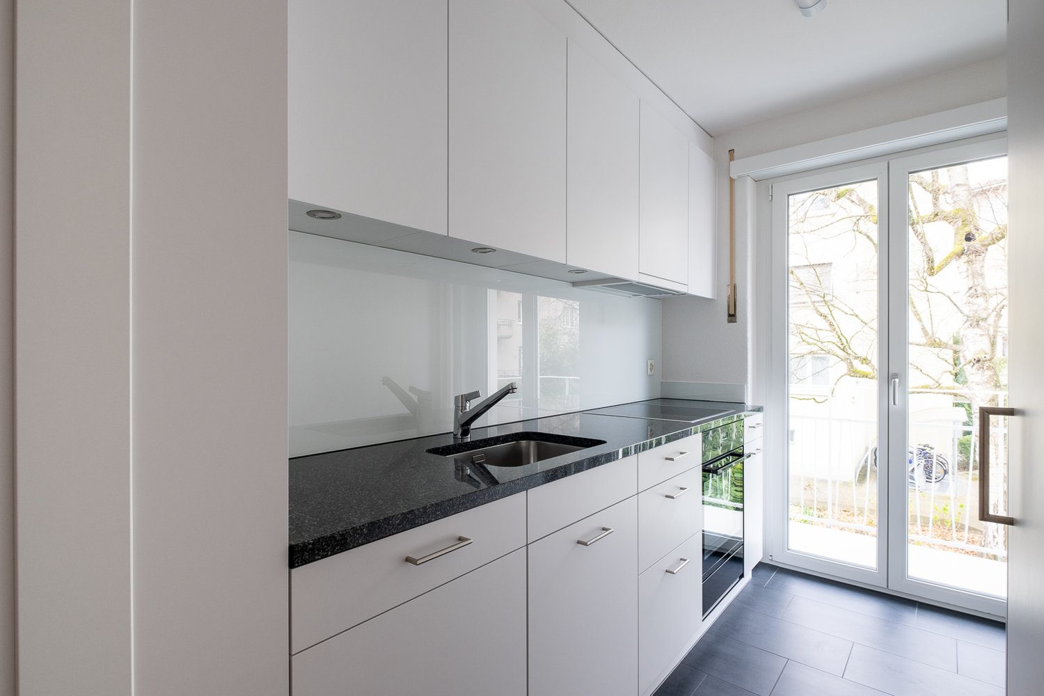 white cabinets, granite countertops, stainless steel faucet, modern sink, glass door