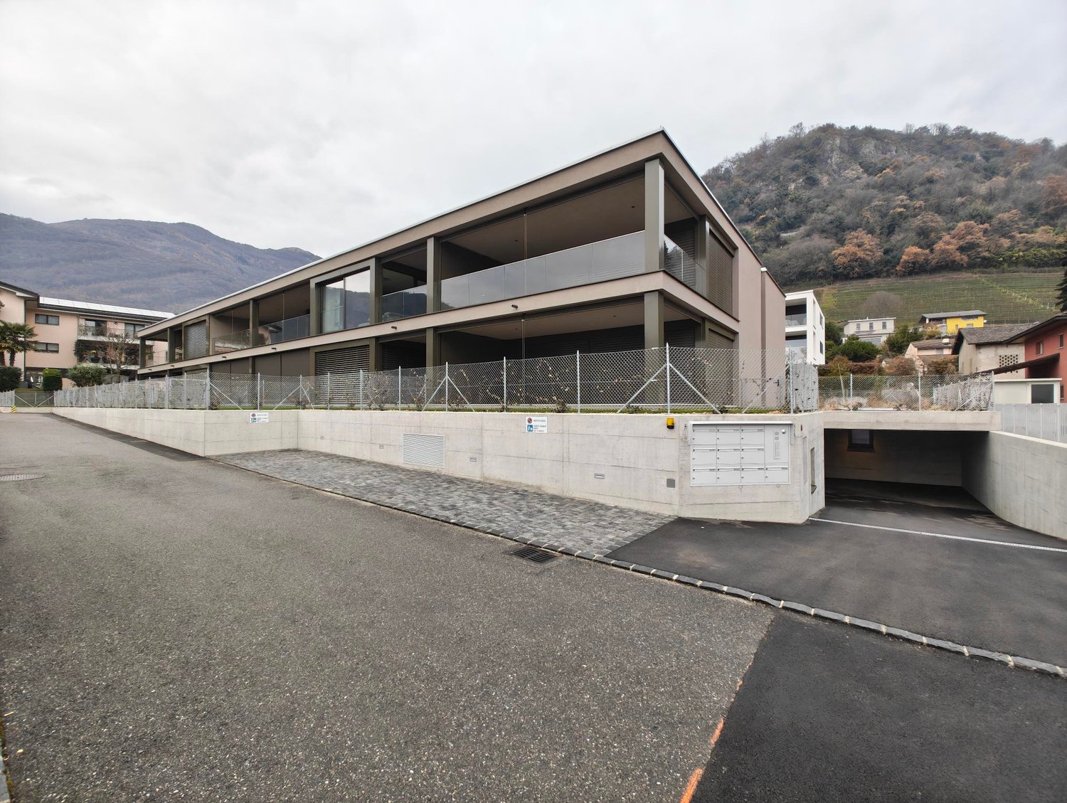 multistory house, modern architecture, glass windows, concrete fence, garage, parking lot