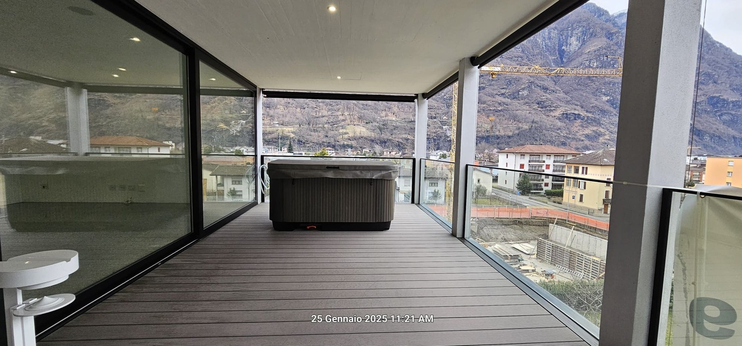 covered balcony, large glass windows, hot tub, wooden floor, mountain view